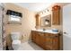 Bathroom with a white countertop, wood cabinets, and a decorative mirror at 17587 Se 95Th Cir, Summerfield, FL 34491