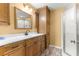 Bathroom featuring wood cabinets, a shower, and a white countertop sink at 17587 Se 95Th Cir, Summerfield, FL 34491