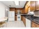 Kitchen featuring wood cabinets, granite countertops, and stainless steel appliances at 17587 Se 95Th Cir, Summerfield, FL 34491