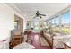 Bright sun room featuring comfortable seating, ceiling fan, and views of the surrounding yard at 17587 Se 95Th Cir, Summerfield, FL 34491