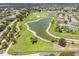 Scenic aerial view of a golf course community with lush greenery and a serene lake at 1875 Saybrook Way, The Villages, FL 32162