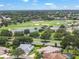Aerial view of residential community featuring golf course, ponds, and lush trees at 1875 Saybrook Way, The Villages, FL 32162