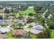 Residential aerial view showcasing landscaping, golf course, and a pond at 1875 Saybrook Way, The Villages, FL 32162