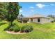 Well-maintained backyard showcasing a sunroom extension, lush lawn, and blooming flowers, perfect for outdoor enjoyment at 1875 Saybrook Way, The Villages, FL 32162