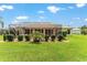 The spacious backyard features a screen patio, green lawn, and lush landscaping for relaxation and outdoor living at 1875 Saybrook Way, The Villages, FL 32162