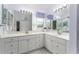 Bathroom with double sinks and granite countertop vanity, large mirrors, and cabinet storage at 1875 Saybrook Way, The Villages, FL 32162