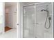 Bathroom with a walk-in shower featuring clear glass doors and white tiled walls at 1875 Saybrook Way, The Villages, FL 32162