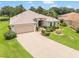 Charming home featuring a well-maintained lawn, mature landscaping, and an attached two-car garage at 1875 Saybrook Way, The Villages, FL 32162