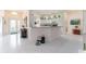 Open foyer showcases a white tile floor, kitchen, and bright natural light from the front door at 1875 Saybrook Way, The Villages, FL 32162