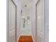 Hallway access to closets and the bathroom featuring tile flooring, a mirror, and towel rack at 1875 Saybrook Way, The Villages, FL 32162