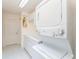 Functional laundry room with a stacked washer and dryer, sink, and white cabinetry at 1875 Saybrook Way, The Villages, FL 32162