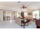 Bright living room boasts neutral tile flooring, ceiling fan, and sliding door access to the outdoor patio at 1875 Saybrook Way, The Villages, FL 32162