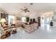 Inviting living room with tile floors, ceiling fan, and comfortable seating for entertaining guests at 1875 Saybrook Way, The Villages, FL 32162
