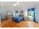 Bright main bedroom features hardwood floors, ceiling fan, closet, large windows, and ensuite bathroom at 1875 Saybrook Way, The Villages, FL 32162