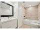 Updated bathroom with sleek vanity, large mirror, modern lighting, and tiled shower-tub combination at 1909 S Atlantic Ave # 311312, Daytona Beach, FL 32118