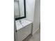 Bathroom featuring a modern vanity with a black framed mirror and light wood-style flooring at 1909 S Atlantic Ave # 311312, Daytona Beach, FL 32118