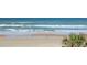 A scenic view of the beach with waves and a person walking on the shoreline at 1909 S Atlantic Ave # 311312, Daytona Beach, FL 32118
