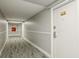 Hallway leading to different units, featuring carpeted flooring, white walls, and a door numbered 311 at 1909 S Atlantic Ave # 311312, Daytona Beach, FL 32118