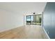 Bright living room featuring wood floors, ceiling fan, large windows with views, and blue accent wall at 1909 S Atlantic Ave # 311312, Daytona Beach, FL 32118