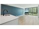 Bright living room with modern floors, a bar sink, large window and a blue accent wall at 1909 S Atlantic Ave # 311312, Daytona Beach, FL 32118