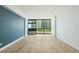 Bright living room with modern floors, large window with a view and a blue accent wall at 1909 S Atlantic Ave # 311312, Daytona Beach, FL 32118