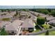 This aerial view features a community of single-story homes, mature trees, and manicured lawns with rock features at 2128 Alfredo Ave, Lady Lake, FL 32159