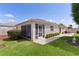 A serene backyard featuring a screened in lanai, green lawn, and manicured hedges, perfect for outdoor relaxation at 2128 Alfredo Ave, Lady Lake, FL 32159