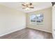 Bright bedroom featuring wood-look floors, a ceiling fan, and a window offering natural light at 2139 Kaylee Dr, The Villages, FL 32162