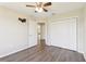 Bedroom showcasing neutral walls, wood-look flooring, a closet, and a ceiling fan at 2139 Kaylee Dr, The Villages, FL 32162