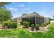 Exterior screened-in porch, trimmed hedges, and a lush green lawn at 2139 Kaylee Dr, The Villages, FL 32162