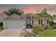 Charming single-story home with tan siding, red shutters, well-manicured landscaping, and two-car garage at 2139 Kaylee Dr, The Villages, FL 32162