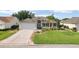 Beautiful single-story home showcasing a lush, landscaped front yard, attached garage, and charming curb appeal at 2139 Kaylee Dr, The Villages, FL 32162