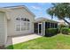 Home exterior featuring a screened lanai, a well-manicured lawn, and tasteful landscaping at 2139 Kaylee Dr, The Villages, FL 32162