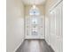 Inviting foyer with a decorative glass front door, transom window and gray laminate wood flooring at 2139 Kaylee Dr, The Villages, FL 32162