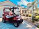 Lovely home featuring a new golf cart parked on the driveway amid lush landscaping and sunny skies at 2139 Kaylee Dr, The Villages, FL 32162