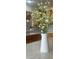 Close up of white vase with white flowers and wooden cabinets with gray back splash at 2139 Kaylee Dr, The Villages, FL 32162