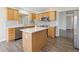Contemporary kitchen with stainless steel appliances, center island, and wooden cabinetry at 2139 Kaylee Dr, The Villages, FL 32162