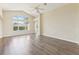 Bright living room featuring laminate wood flooring, vaulted ceilings, a ceiling fan, and large windows at 2139 Kaylee Dr, The Villages, FL 32162