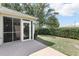 Back patio with a screened-in porch, well-maintained hedges, and a comfortable outdoor space at 2139 Kaylee Dr, The Villages, FL 32162