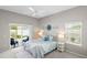 Cozy bedroom with a ceiling fan, light-colored walls, a plush carpet, a sliding glass door and large window at 2293 Wayland St, The Villages, FL 32162