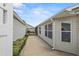 Exterior side view of home with walkway to screened patio with awning, and many windows at 2293 Wayland St, The Villages, FL 32162