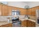 Close up of kitchen with stainless steel appliances, granite countertops, tile backsplash and wood cabinets at 2293 Wayland St, The Villages, FL 32162