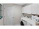 Well-lit laundry room with storage cabinets and modern washer and dryer at 2293 Wayland St, The Villages, FL 32162