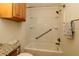 Bathroom with shower and tub combination with shower and safety bar, storage cabinet on the wall at 2449 Kingstree Pl, The Villages, FL 32162