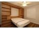 Bedroom with a built-in wall bed and shelving unit and window with plantation shutters at 2449 Kingstree Pl, The Villages, FL 32162