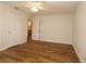 Spacious bedroom boasts wood-look floors, ceiling fan, and convenient ensuite access at 2449 Kingstree Pl, The Villages, FL 32162