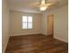 Bright bedroom featuring wood-look floors, neutral walls, and a ceiling fan at 2449 Kingstree Pl, The Villages, FL 32162