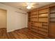 Bedroom with an installed wall bookshelf and storage on a hardwood floor and ceiling fan at 2449 Kingstree Pl, The Villages, FL 32162