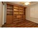 Bedroom with an installed wall bookshelf and storage, ceiling fan, and window with plantation shutters at 2449 Kingstree Pl, The Villages, FL 32162
