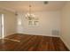 Dining room features wood floors, elegant lighting, and smooth transition to another part of the house at 2449 Kingstree Pl, The Villages, FL 32162